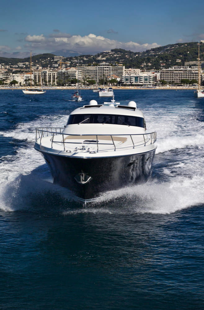 Yacht de location à Cannes qui s'éloigne de la côte sur la mer bleu.