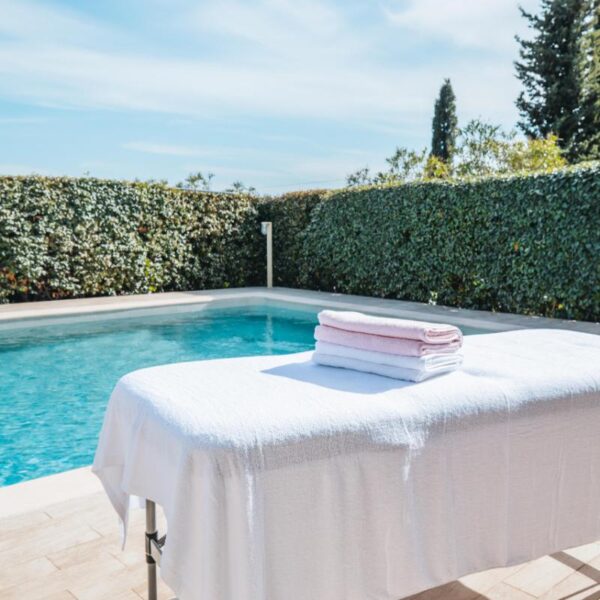 Table de massage près d’une piscine extérieure ensoleillée