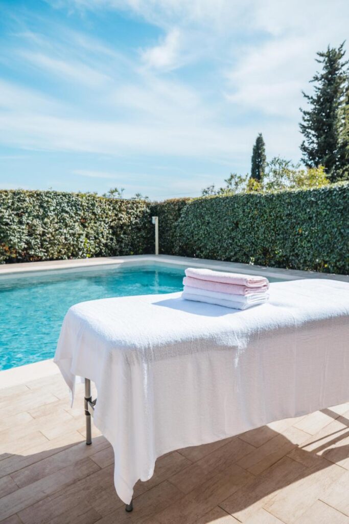 Table de massage près d’une piscine extérieure ensoleillée