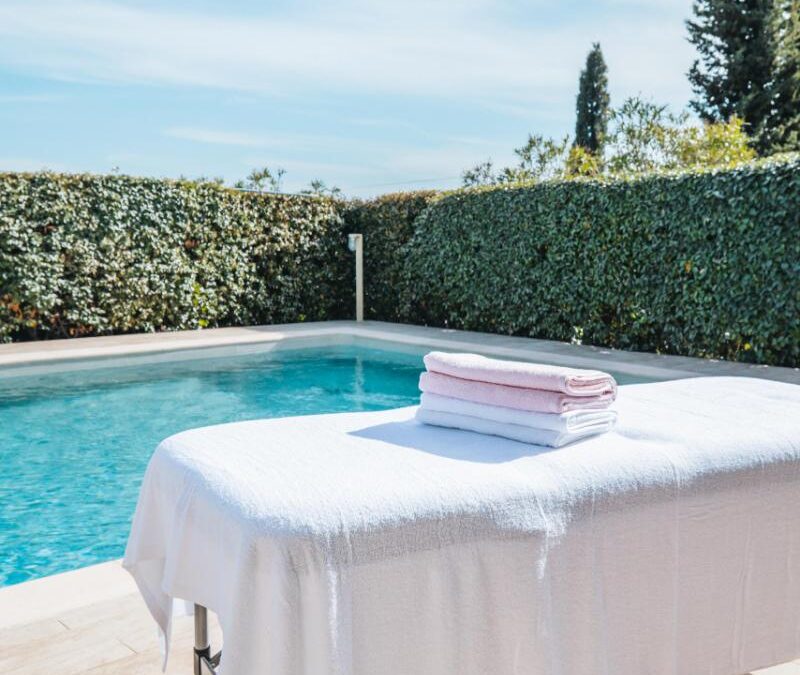 Table de massage près d’une piscine extérieure ensoleillée