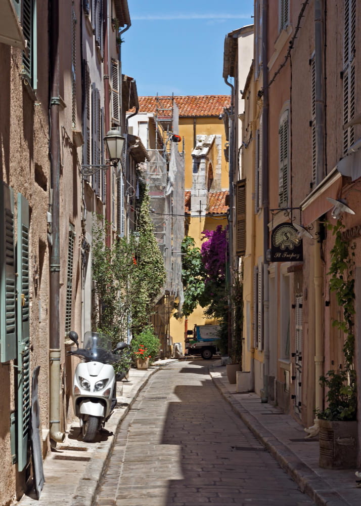 View of a typical alleyway in Saint-Tropez with orange-coloured buildings.