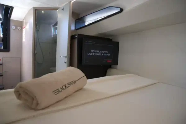 Cabine moderne avec lit, télévision et salle de bain