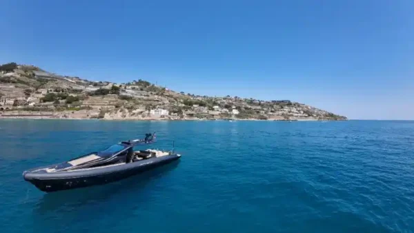 Bateau à moteur moderne près d’une côte rocheuse